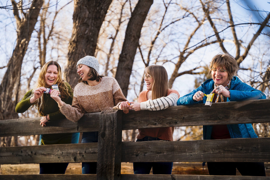 four people holding organic snack bars 