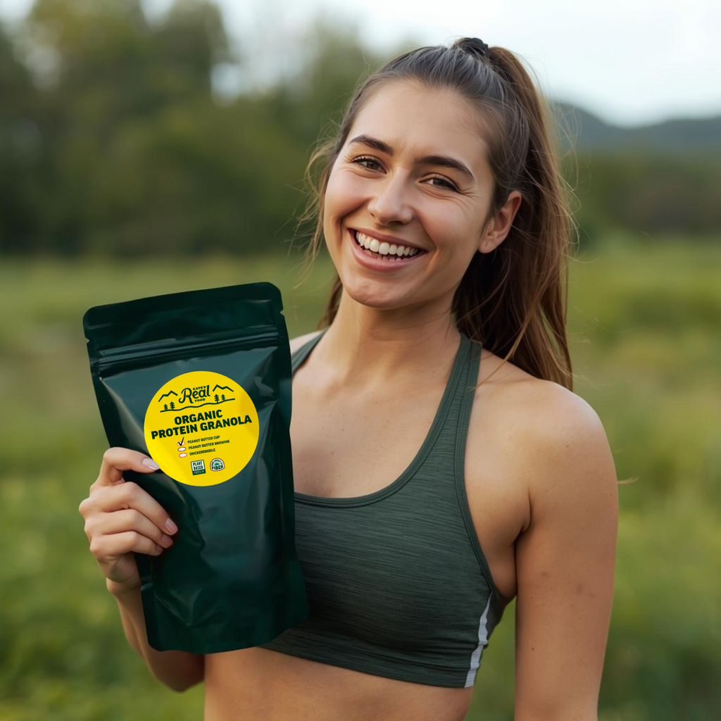 Woman holding a package of Organic Protein Granola in a green field